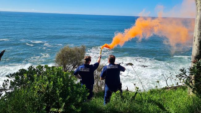 Paramedics hold a flare to alert the rescue helicopter as to the location of the incident.