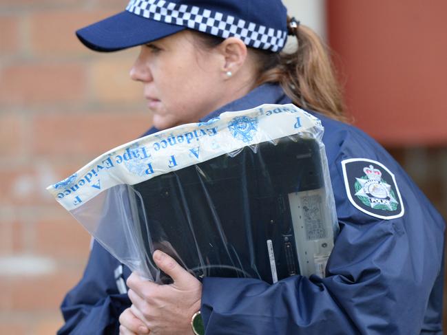 Australian Federal Police (AFP) remove a laptop in an evidence bag from an address at Ascot Vale, Melbourne, Friday, May 9, 2017. About 150 people from state and federal police and national security service ASIO simultaneously raided properties in three Melbourne suburbs this morning. (AAP Image/Mal Fairclough) NO ARCHIVING