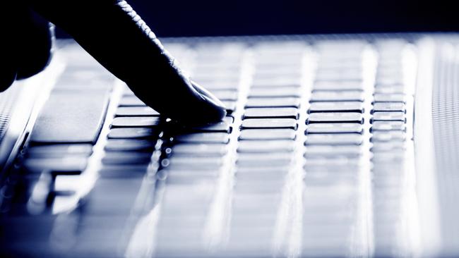 Concept photo in high contrast black and white of hacker's single finger on keyboard