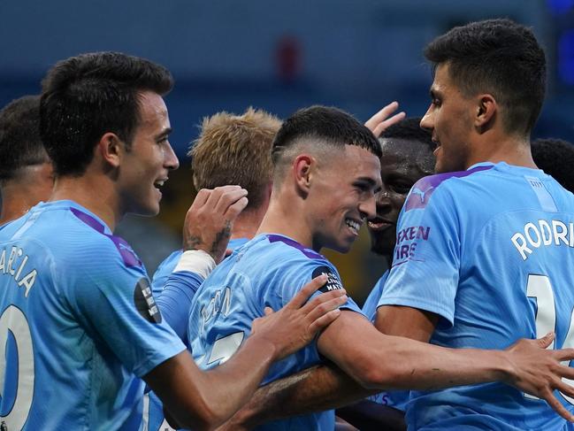 Manchester City players celebrate after Phil Foden (C) scored their third goal during the English Premier League football match between Manchester City and Liverpool at the Etihad Stadium in Manchester, north west England, on July 2, 2020. (Photo by Dave Thompson / POOL / AFP) / RESTRICTED TO EDITORIAL USE. No use with unauthorized audio, video, data, fixture lists, club/league logos or 'live' services. Online in-match use limited to 120 images. An additional 40 images may be used in extra time. No video emulation. Social media in-match use limited to 120 images. An additional 40 images may be used in extra time. No use in betting publications, games or single club/league/player publications. /