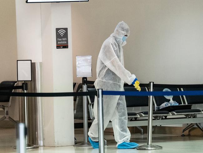 PERTH, AUSTRALIA  - NewsWire Photos DECEMBER 18, 2020: Cleaners clean handrails after Jet Star Passengers came through the wrong gate arriving from Sydney after Western Australia initiated a hard border with NSW in the wake of fresh Covid cases. Picture: NCA NewsWire / Tony McDonough