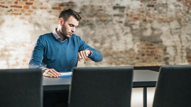 CAREERS: Young businessman checking the time while waiting for HR team on a job interview. Copy space.