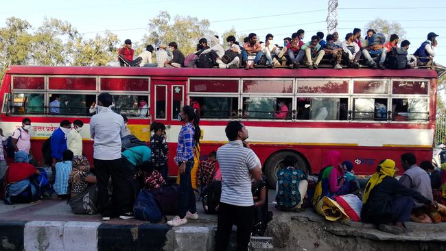 Migrant workers and their family members gather outside the Anand Vihar bus terminal to leave for their villages. Picture: Bhuvan Bagga/AFP