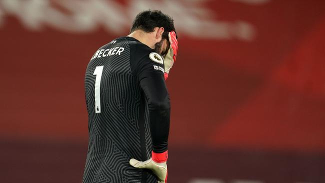 Liverpool's Brazilian goalkeeper Alisson Becker reacts after conceding their third goal during the English Premier League football match between Liverpool and Manchester City at Anfield in Liverpool, north west England on February 7, 2021. (Photo by Jon Super / POOL / AFP) / RESTRICTED TO EDITORIAL USE. No use with unauthorized audio, video, data, fixture lists, club/league logos or 'live' services. Online in-match use limited to 120 images. An additional 40 images may be used in extra time. No video emulation. Social media in-match use limited to 120 images. An additional 40 images may be used in extra time. No use in betting publications, games or single club/league/player publications. /