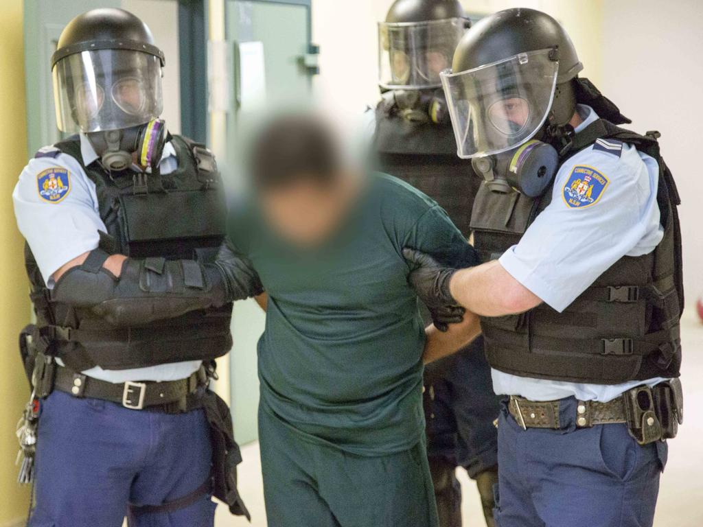 An inmate is escorted by three officers inside Supermax, which serial killer Ivan Milat said had wrongly been likened to a gulag.