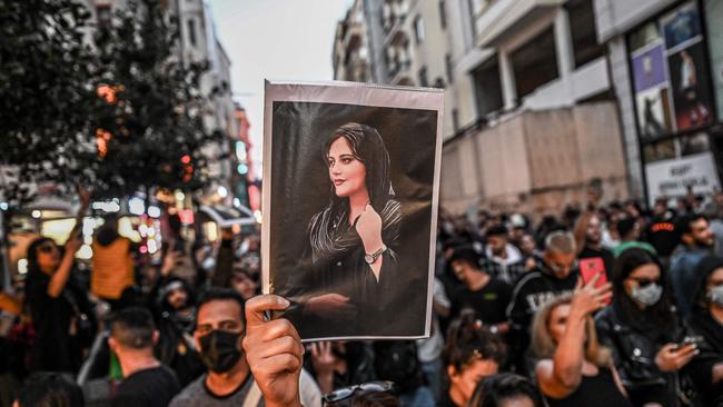 A protester holds a portrait of Mahsa Amini during a demonstration in support of Amini, a young Iranian woman who died after being arrested in Tehran by the Islamic Republic's morality police.
