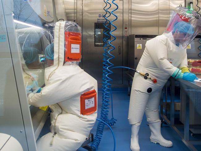 Workers next to a cage with mice inside the P4 laboratory in Wuhan, capital of China's Hubei province. Picture: AFP