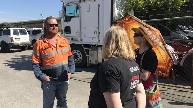 A worker talks to protesters at a Pinkenba property.