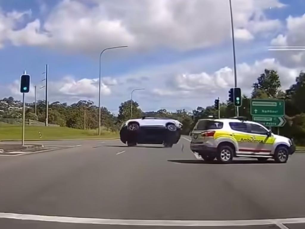 Dash cam footage shows the moment an ambulance with its lights on collides with another car on a busy intersection. Picture: Dash Cam Owners Australia