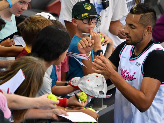 Nick Kyrgios signs autographs after a practice session in Brisbane on Sunday. Picture: Saeed Khan/AFP