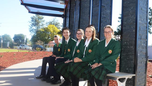 Students Corbin Amos, Ryan Pike, Sara Hockings, Hanna McIvor and Luci Donovan sit on the new benches outside the front of Assumption College.