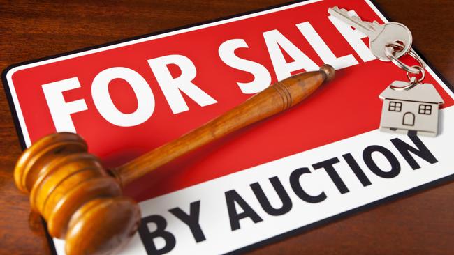 "Home for Sale by Auction. For Sale sign with auctioneeraas gavel and a chrome house key fob, with house key. Copy space."