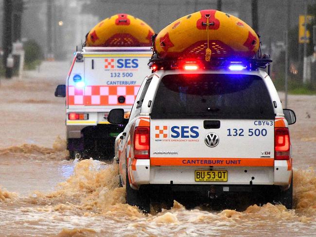 TOPSHOT - State Emergency Service vehicles approach flooded residential areas in western Sydney on March 20, 2021, amid mass evacuations being ordered in low-lying areas along Australia's east coast as torrential rains caused potentially "life-threatening" floods across a region already soaked by an unusually wet summer. (Photo by Saeed KHAN / AFP)