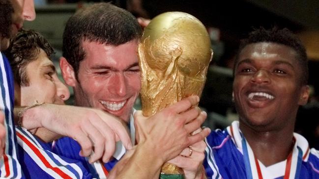 Zinedine Zidane (centre) holds the World Cup trophy in 1998. Photo: AP