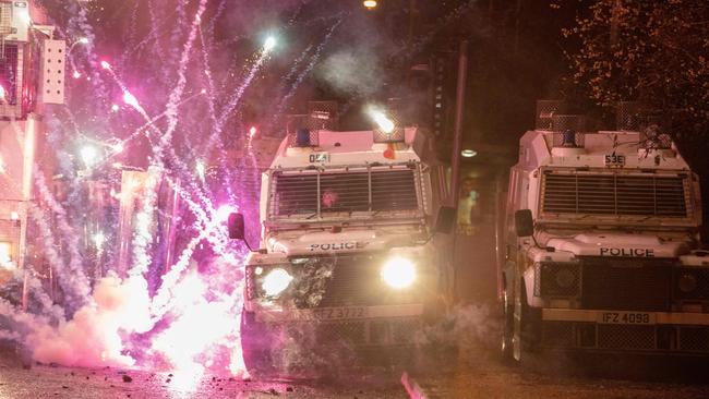 Police Land Rovers are targeted by fireworks during clashes with Republican youths in the Springfield Road area of Belfast on Thursday night. Picture: AFP