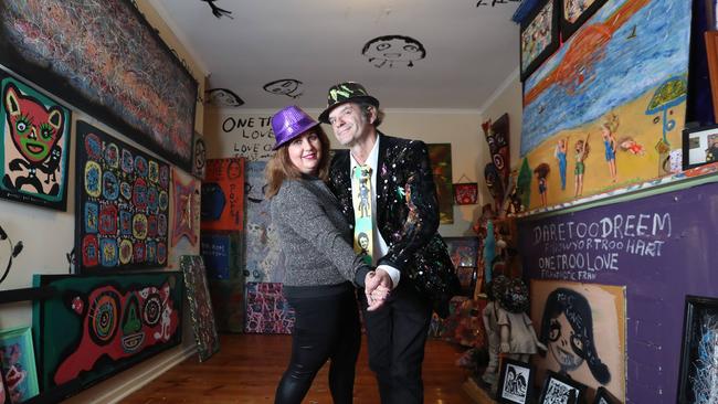 Fran Ferrauto and Jungle Phillips inside Jungle’s Marion Rd home, which is covered in art. Picture: Tait Schmaal