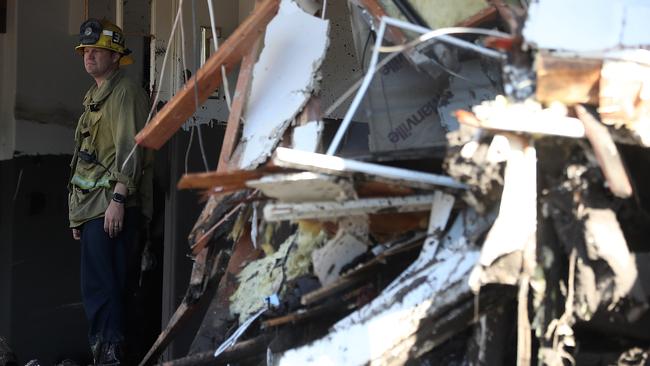 A firefighter stands in a home damaged by the mudslide. Picture; AFP.