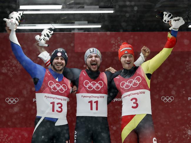 Silver medallist Chris Mazdzer of the United States, gold medallist David Gleirscher of Austria and bronze medallist Johannes Ludwig of Germany hold up their tigers at the podium. Picture: Andy Wong/AP