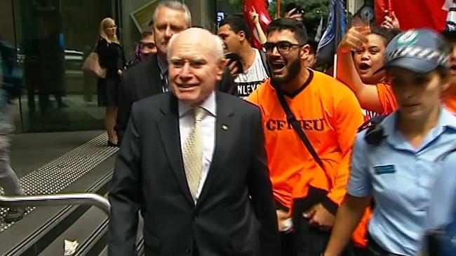 Former prime minister John Howard is jostled and heckled by union protester earlier this month in Sydney.