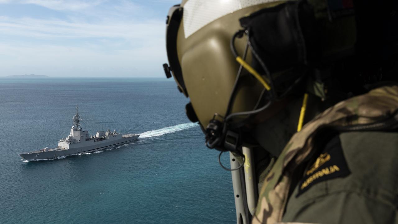 Leading Seaman Aircrewman Liam Sulley looks out towards HMAS Brisbane as the ship transits through the Prince of Wales Channel, off the coast of Queensland. Picture: Defence