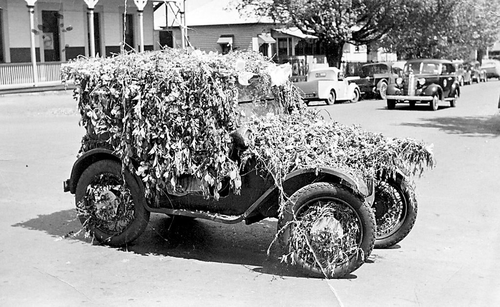 FLOWER POWER: Lesley Turner has sent in this picture of an Austin A7 decorated for an early Carnival of Flowers parade by her father Les. The windscreen was boarded up so spectators could not see into the car. The picture was taken on the corner of James and Ruthven streets. Photo: Contributed