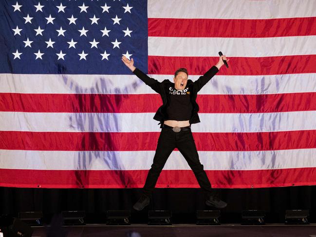 Elon Musk jumps for joy on stage at a town hall event in support of Donald Trump during the incoming President’s race to the White House. Picture: AFP