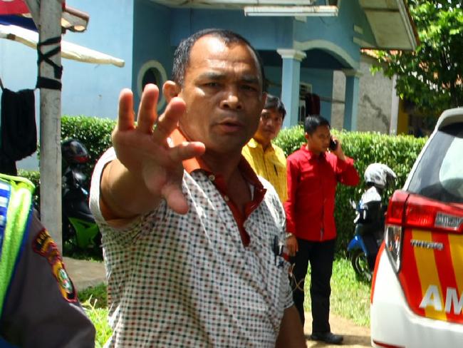 CORRECTION - A plainclothes police officer gestures to photographers as police secure a house after a firefight erupted as alleged militants had opened fire at officers in South Tangerang, 25 kilometres (15 miles) outside the capital Jakarta, on December 21, 2016. Indonesian police have foiled plans for a Christmas suicide bombing after killing three suspected militants on December 21 and discovering a cache of bombs, authorities said. / AFP PHOTO / Demy SANJAYA / “The erroneous mention[s] appearing in the metadata of this photo by Demy SANJAYA has been modified in AFP systems in the following manner: [South Tangerang] instead of [Jakarta] for the dateline. Please immediately remove the erroneous mention[s] from all your online services and delete it (them) from your servers. If you have been authorized by AFP to distribute it (them) to third parties, please ensure that the same actions are carried out by them. Failure to promptly comply with these instructions will entail liability on your part for any continued or post notification usage. Therefore we thank you very much for all your attention and prompt action. We are sorry for the inconvenience this notification may cause and remain at your disposal for any further information you may require.”