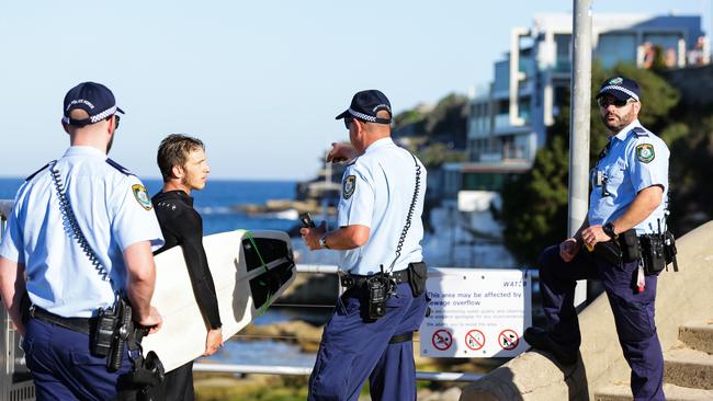 Police speak to a surfer at Bondi — a scene alien to South Australians who have enjoyed less rigid rules. Picture: Gaye Gerard/News Corp