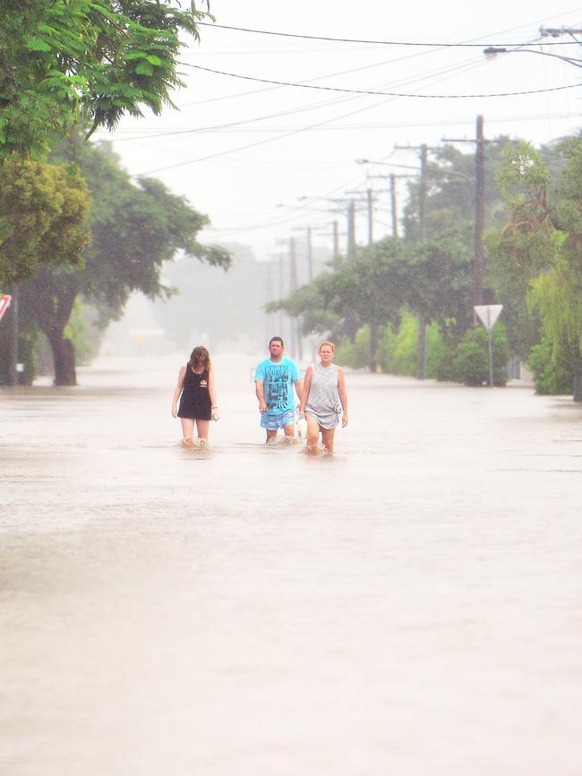 People walk through floodwaters in Townsville. Picture: Zak Simmonds