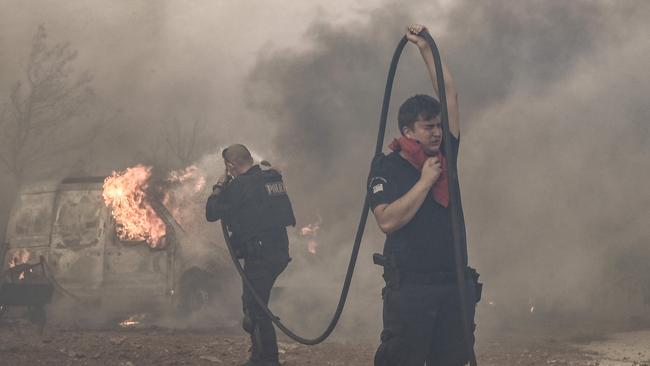 Firefighters battle flames southeast of Athens on Monday. Picture: AFP