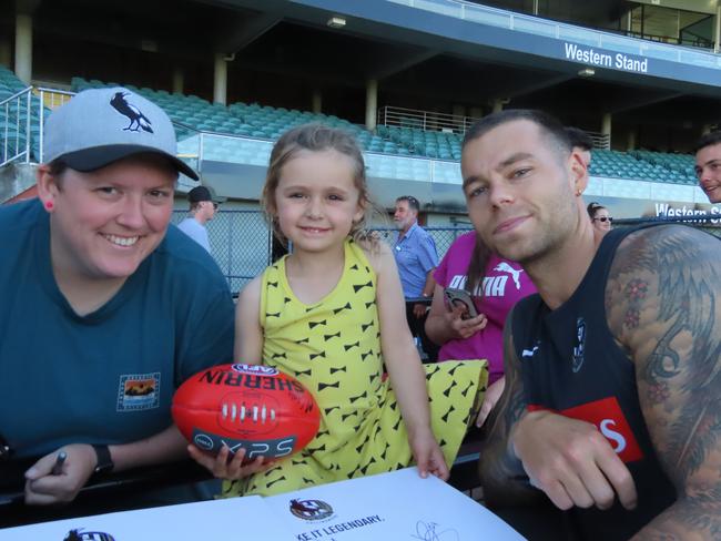 Alicia Cook and Piper, four, with Collingwood player Jamie Elliott. Picture: Jon Tuxworth