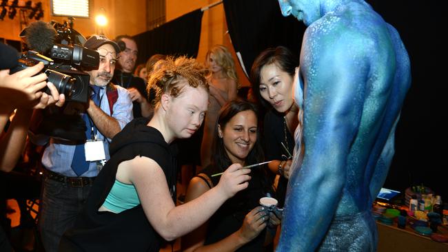 Madeline Stuart painting the blue men at New York Fashion Week. Pic Alex Towle