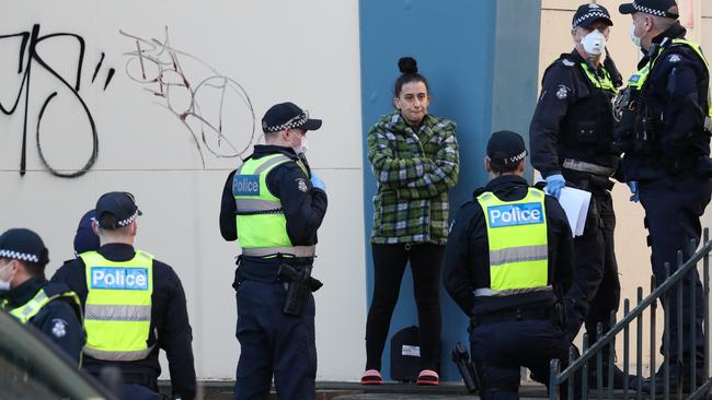 Officers speaking to the woman in Flemington who could be heard shouting she was just going for coffee. Picture: David Crosling