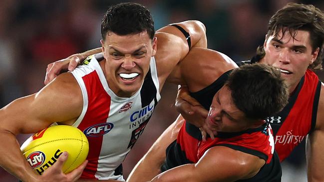 MELBOURNE, AUSTRALIA - MARCH 30: Marcus Windhager of the Saints is tackled by Archie Perkins of the Bombers during the round three AFL match between Essendon Bombers and St Kilda Saints at Marvel Stadium, on March 30, 2024, in Melbourne, Australia. (Photo by Quinn Rooney/Getty Images)