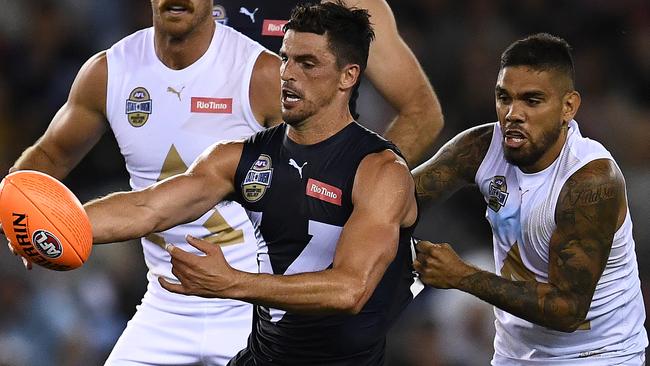 MELBOURNE, AUSTRALIA - FEBRUARY 28: Scott Pendlebury of Victoria kicks whilst being tackled during the AFL Bushfire Relief State of Origin match between Victoria and the All Stars at Marvel Stadium on February 28, 2020 in Melbourne, Australia. (Photo by Quinn Rooney/Getty Images)