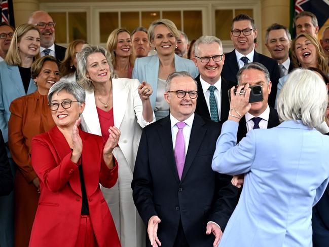 TOPSHOT - Australia's Governor General Sam Mostyn shows a selfie to Australia's re-elected Prime Minister Anthony Albanese (C) and his cabinet members after a swearing-in ceremony at Government House in Canberra on May 13, 2025. (Photo by Saeed Khan / AFP)