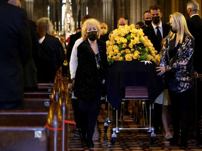 Patti and Lauren Newton - and her husband Matt Welsh - along with pallbearers accompany Bert’s casket after the service. Picture: Getty