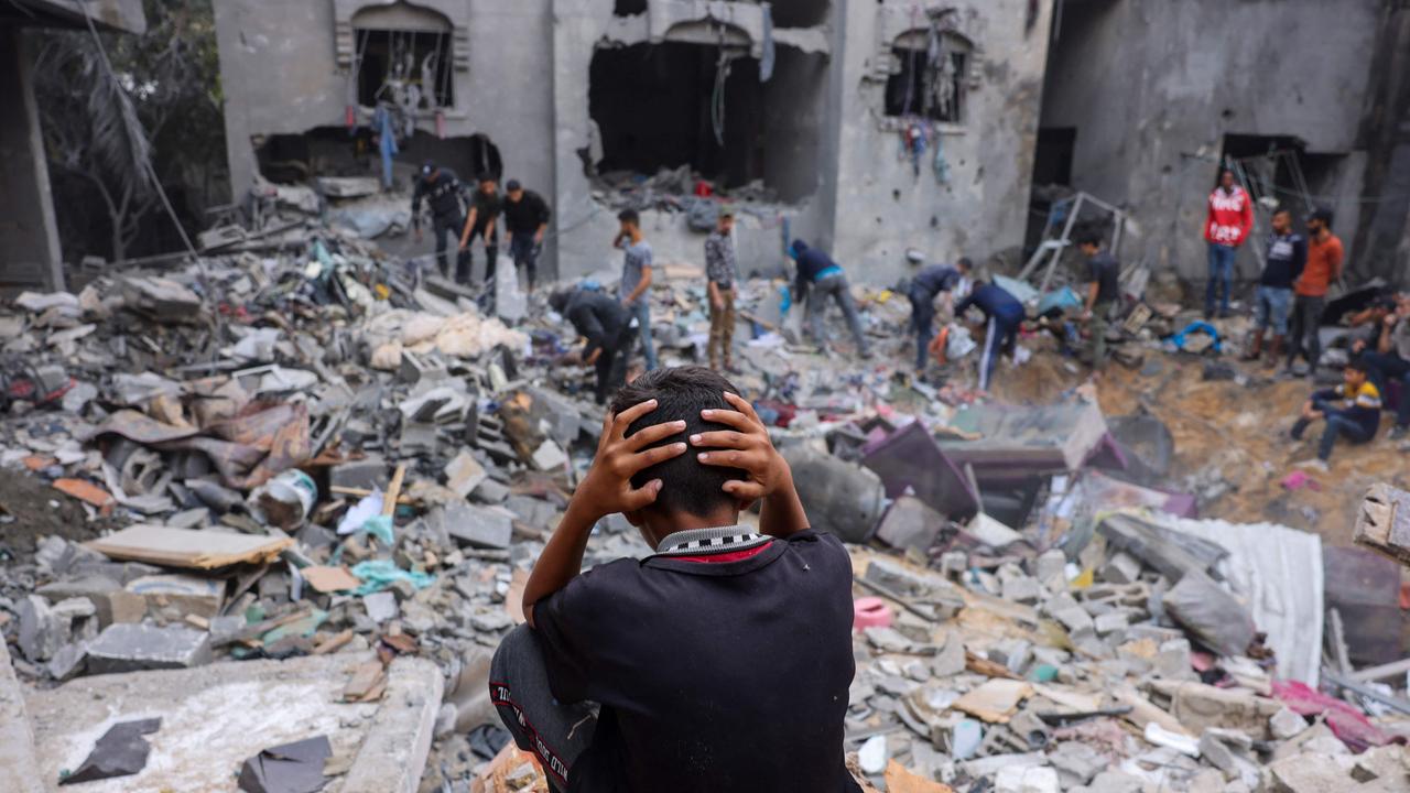 People salvage belongings amid the rubble of a damaged building following strikes on Rafah in the southern Gaza Strip. Picture: AFP