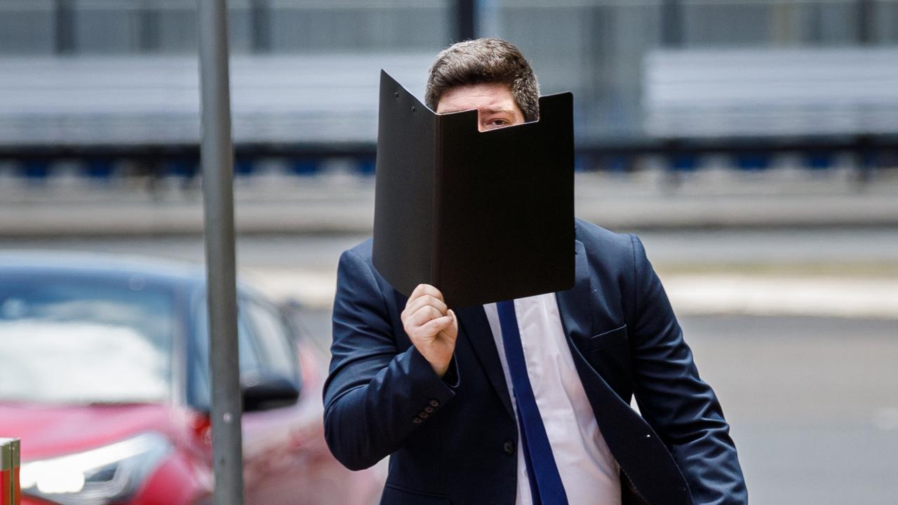 The former police officer attempted to hide his face as he entered the courthouse on Friday. Picture: NCA NewsWire / Max Mason-Hubers