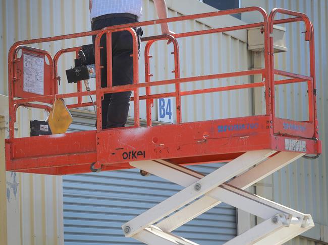 State Coroner Mark Johns, counsel assisting and other lawyers, viewing the scissor lift that killed Jorge Castillo-Riffo. At the Ottaway police compound at 2.15pm, Wednesday 21 March. (AAP Image/Dean Martin)