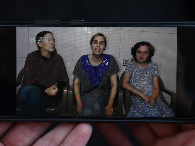 A phone displays footage released by Hamas showing three hostages, purportedly held in captivity in Gaza. Picture: Getty Images