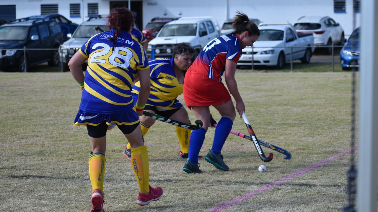 Townsville teammates Emily Norton and Lew Urquhart take on Warwick's Danielle Cook as she heads towards the goal in the 2021 Queensland Hockey Women's Masters Championships at Warwick.