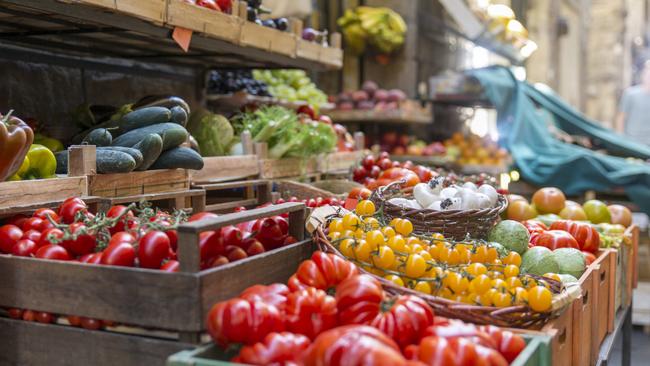 Fresh and healthy vegetables and colorful fruit in front of a shop in a picturesque street in Italy