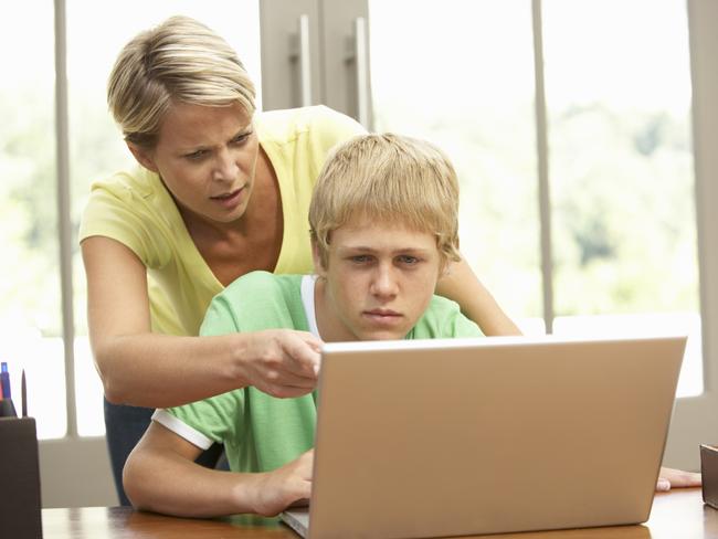 Angry Mother and Teenage Son Using Laptop. Computer. Children. Kids. Parents. Generic image.