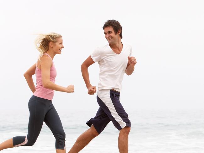 Couple exercising on the beach. Generic image