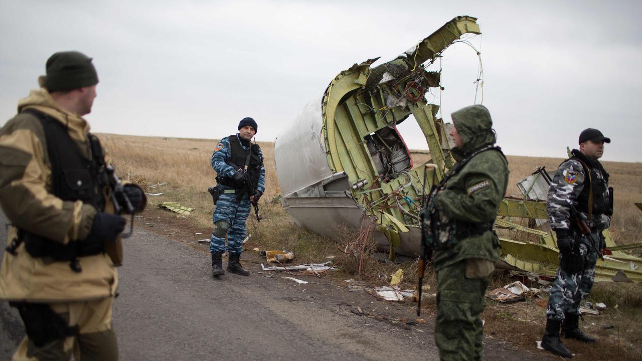 Pro-Russian gunmen guard parts of Malaysia Airlines Flight MH17 at the crash site. (Photo by Menahem KAHANA / AFP)