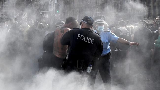 Police detain a man in Sydney’s CBD, where thousands marched in breach of pulic health orders on Saturday. Picture: Matrix