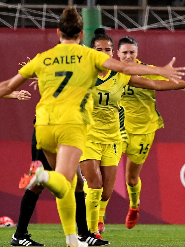 Fowler’s teammates run in to congratulate her after the hit. Picture: AFP