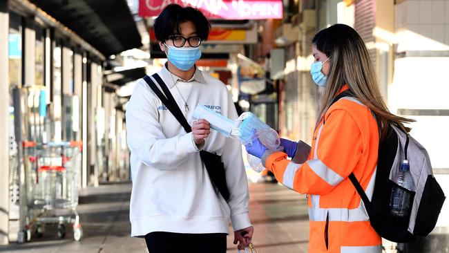 A volunteer distributes face masks in Bankstown, southwest Sydney, on Wednesday. Picture: AFP