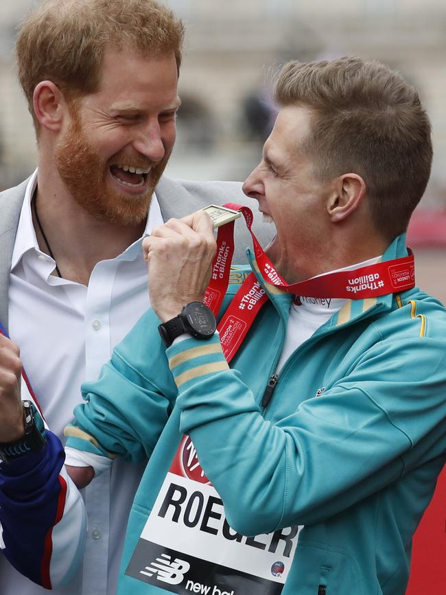 Winner of the World Para marathon T 45/46 category Michael Roger of Australia, shares a special moment with Britain's Prince Harry during the presentation ceremony at the 39th London Marathon in London. Picture: AP Photo/Alastair Grant